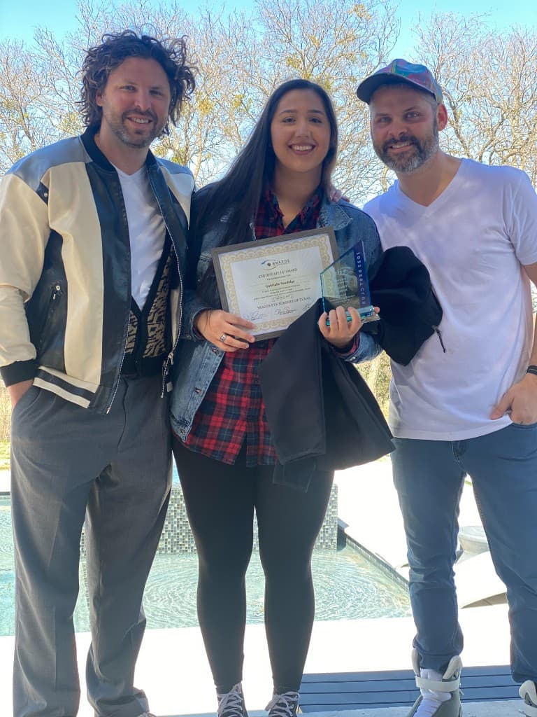 Brazos Eye employee receiving an award certificate poolside with team members