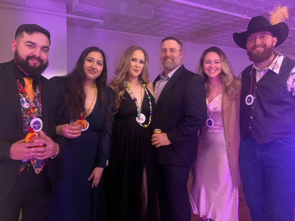 Brazos Eye team dressed up at a Mardi Gras–themed company celebration